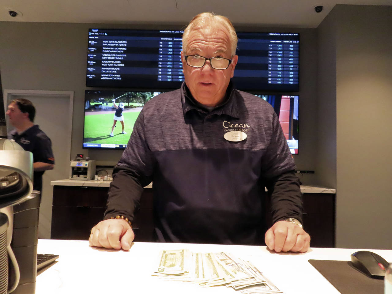 Frank Caltagirone, a sports book employee at the Ocean Casino Resort in Atlantic City, N.J., counts...