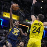 
              Indiana Pacers guard Bennedict Mathurin (00) shoots over Utah Jazz center Walker Kessler (24) during the first half of an NBA basketball game in Indianapolis, Monday, Feb. 13, 2023. (AP Photo/Michael Conroy)
            