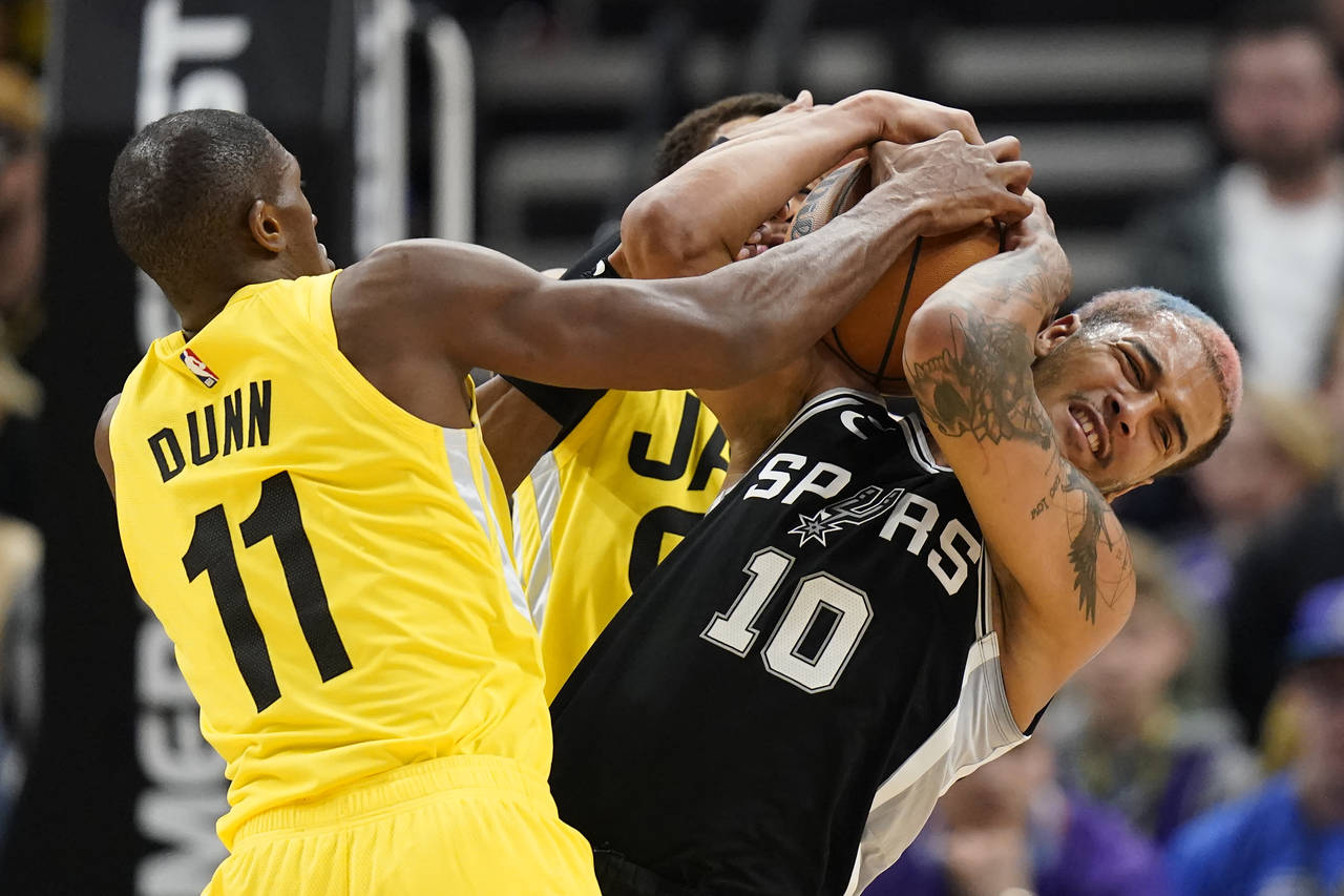 San Antonio Spurs forward Jeremy Sochan (10) battles Utah Jazz guard Kris Dunn (11) for a.loose bal...