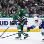 
              Dallas Stars center Tyler Seguin (91) shoots as Vancouver Canucks' Quinn Hughes (43) defends during the first period of an NHL hockey game, Monday, Feb. 27, 2023, in Dallas. (AP Photo/Tony Gutierrez)
            