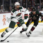 
              Minnesota Wild defenseman Matt Dumba (24) carries the puck in front of Arizona Coyotes left wing Lawson Crouse in the first period during an NHL hockey game, Monday, Feb. 6, 2023, in Tempe, Ariz. (AP Photo/Rick Scuteri)
            