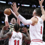 
              Charlotte Hornets' Gordon Hayward shoots as Chicago Bulls' DeMar DeRozan (11) and Nikola Vucevic watch during the first half of an NBA basketball game, Thursday, Feb. 2, 2023, in Chicago. (AP Photo/Charles Rex Arbogast)
            