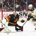 
              Boston Bruins' Jake DeBrusk (74) tries to get his stick on the loose puck after Vancouver Canucks goalie Arturs Silovs (31) made a pad save during the second period of an NHL hockey game, Saturday, Feb. 25, 2023 in Vancouver, British Columbia. (Rich Lam/The Canadian Press via AP)
            