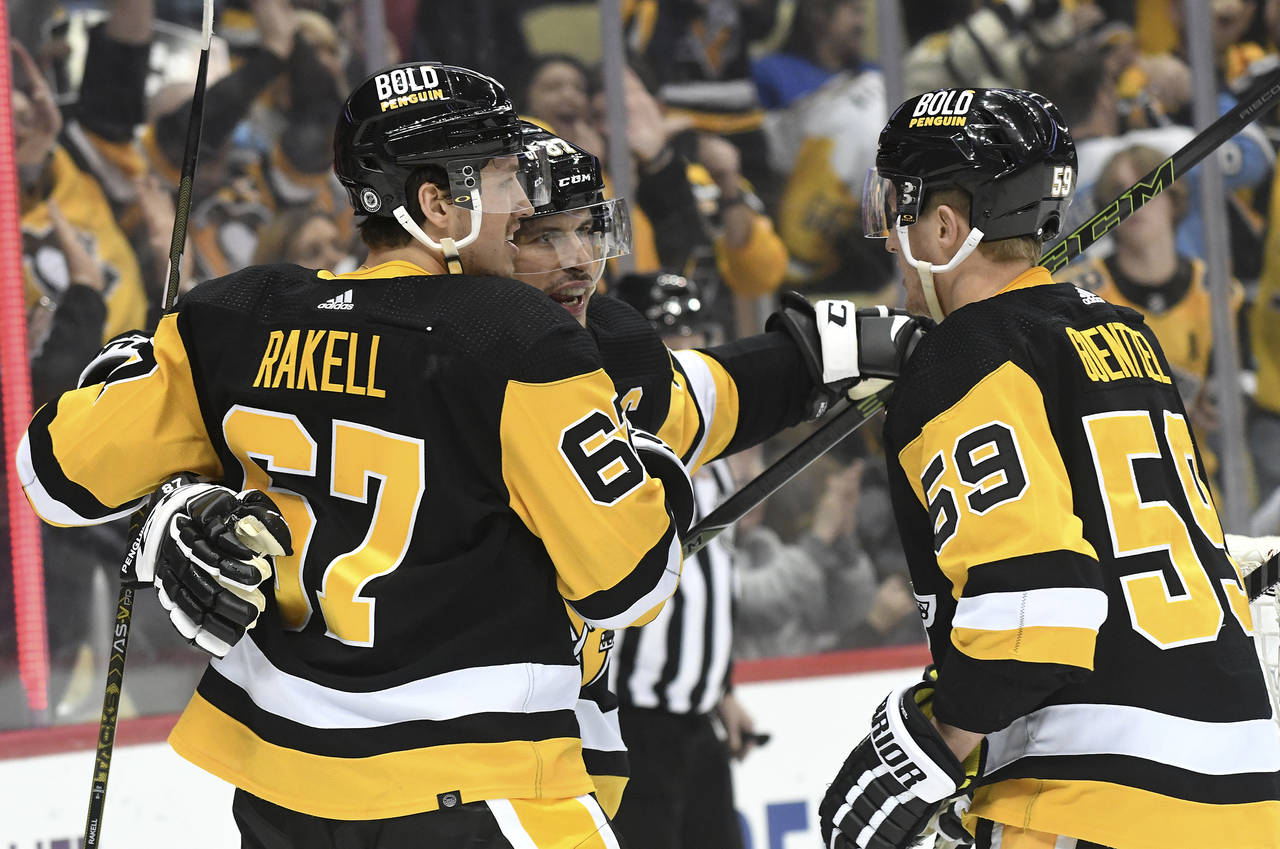 Pittsburgh Penguins center Sidney Crosby (87) celebrates with Rickard Rakell (67) and Jake Guentzel...