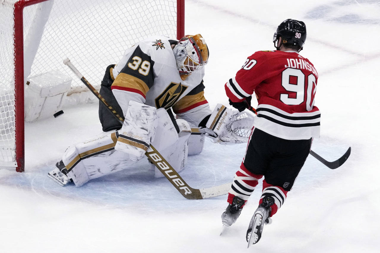 Vegas Golden Knights goaltender Laurent Brossoit, left, can't make a save a goal hit by Chicago Bla...