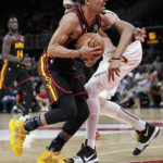 
              Atlanta Hawks guard Trae Young, front, drives against Cleveland Cavaliers center Jarrett Allen during the first half of an NBA basketball game Friday, Feb. 24, 2023, in Atlanta. (AP Photo/John Bazemore)
            