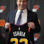 
              Mat Ishbia, new controlling interest owner of the Phoenix Suns and Phoenix Mercury, holds up a jersey as he is introduced to the media during an NBA basketball news conference, Wednesday, Feb. 8, 2023, in Phoenix. (AP Photo/Rick Scuteri)
            