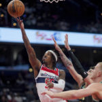 
              Washington Wizards guard Delon Wright (55) scores against the Charlotte Hornets, including Mason Plumlee, right, during the first half of an NBA basketball game Wednesday, Feb. 8, 2023, in Washington. (AP Photo/Jess Rapfogel)
            