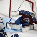 
              Colorado Avalanche goaltender Alexandar Georgiev, right, makes a glove save of a shot off the stick of Tampa Bay Lightning center Ross Colton in the first period of an NHL hockey game, Tuesday, Feb. 14, 2023, in Denver. (AP Photo/David Zalubowski)
            