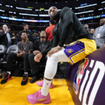 
              Los Angeles Lakers forward LeBron James talks with his kids prior to the second half of an NBA basketball game against the Oklahoma City Thunder Tuesday, Feb. 7, 2023, in Los Angeles. (AP Photo/Ashley Landis)
            