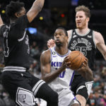 
              Sacramento Kings' Harrison Barnes, center, drives between San Antonio Spurs' Stanley Johnson, left, and Jakob Poeltl during the first half of an NBA basketball game, Wednesday, Feb. 1, 2023, in San Antonio. (AP Photo/Darren Abate)
            