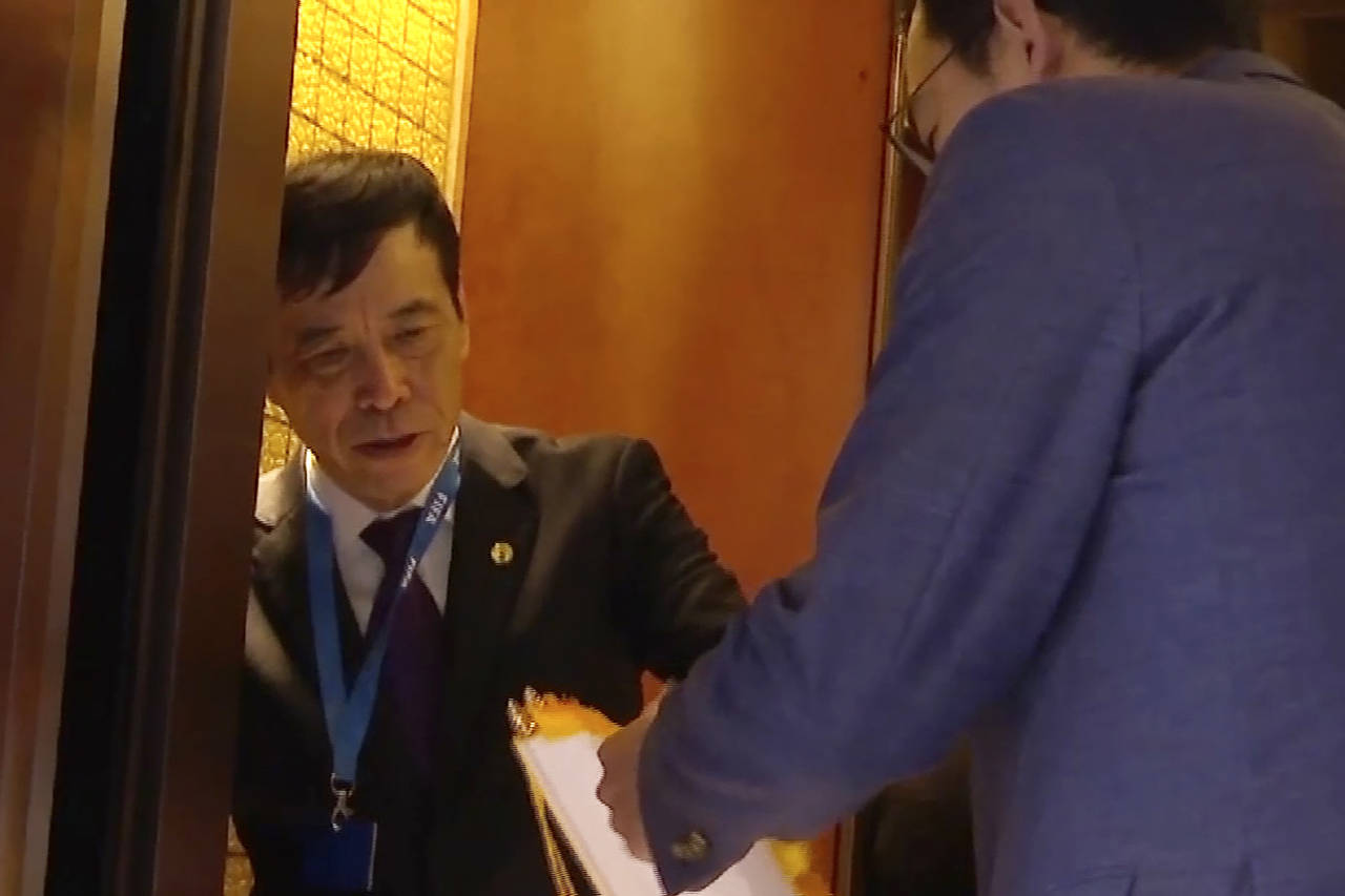 In this image made from video, Chen Xuyuan, head of the Chinese Football Association, gets on an el...