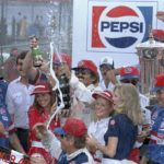
              FILE - Stock car driver and the winner of the 1984 Daytona Firecracker 400 auto race, Richard Petty of Randleman, N.C., sprays champaign in Victory Lane after he won the race Wednesday, July 4, 1984, the Daytona International Speedway. (AP Photo/Elliot Schecter, File)
            