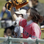 
              A fan for the Yomiuri Giants, a Japanese major league baseball team, cheers during the team's pre-season game against the Tokyo Yakult Swallows in Urasoe, Okinawa prefecture, Japan, Thursday, Feb. 23, 2023. Fans of the upcoming World Baseball Classic are going to see two versions, depending if the games are in the United States, Taiwan, or Japan. (Takahiko Kanbara/Kyodo News via AP)
            