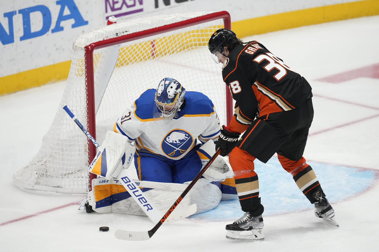 Buffalo Sabres goaltender Eric Comrie (31) stops a shot by Anaheim Ducks center Derek Grant (38) du...
