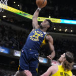 
              Indiana Pacers forward Aaron Nesmith (23) goes up for a dunk over Utah Jazz forward Kelly Olynyk (41) during the first half of an NBA basketball game in Indianapolis, Monday, Feb. 13, 2023. (AP Photo/Michael Conroy)
            