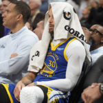
              Golden State Warriors guard Stephen Curry sits on the bench with a towel over his head as time runs out in the second half of an NBA basketball game against the Denver Nuggets Thursday, Feb. 2, 2023, in Denver. (AP Photo/David Zalubowski)
            