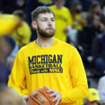 
              Michigan center Hunter Dickinson warms up before the first half of an NCAA college basketball game against Michigan State, Saturday, Feb. 18, 2023, in Ann Arbor, Mich. (AP Photo/Carlos Osorio)
            