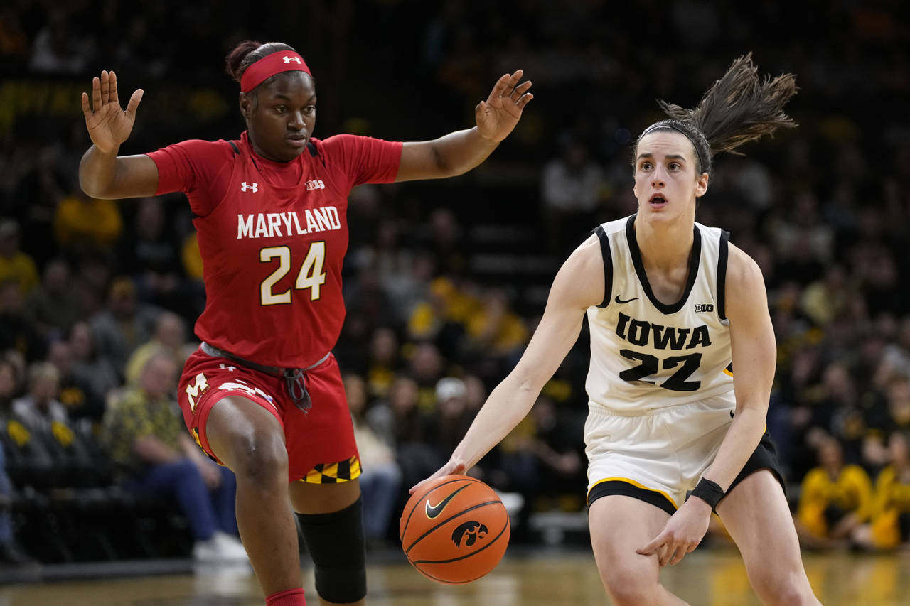 Iowa guard Caitlin Clark (22) drives up court past Maryland guard Bri McDaniel (24) during the seco...