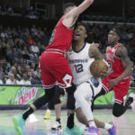 
              Memphis Grizzlies' Ja Morant (12) is closely defended by Chicago Bulls' Zach LaVine (8) during the first half of an NBA basketball game Tuesday, Feb. 7, 2023, in Memphis, Tenn. (AP Photo/Karen Pulfer Focht)
            