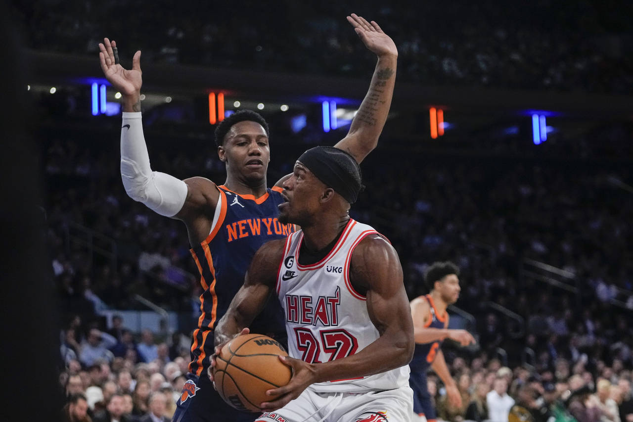 New York Knicks' RJ Barrett, left, defends Miami Heat's Jimmy Butler during the first half of an NB...