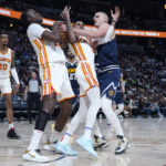 
              Denver Nuggets center Nikola Jokic, right, loses control of the ball to Atlanta Hawks center Clint Capela, front left,, while running into guard Dejounte Murray, center, in the second half of an NBA basketball game Saturday, Feb. 4, 2023, in Denver. (AP Photo/David Zalubowski)
            