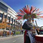 
              FILE - A woman plays a drum during a "No Honor in Racism Rally" in front of TCF Bank Stadium before an NFL football game between the Minnesota Vikings and the Kansas City Chiefs, on Oct. 18, 2015, in Minneapolis. The group objects to the Kansas City Chiefs name, and other teams' use of Native Americans as mascots. As the Kansas City Chiefs return to Super Bowl on Sunday, Feb. 12, 2023, for the first time in two years, the movement to change their name and logo will be there again. (AP Photo/Alex Brandon, File)
            