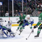 
              Dallas Stars left wing Mason Marchment (27) shoots but is blocked by Vancouver Canucks goaltender Thatcher Demko (35) as Canucks defenseman Christian Wolanin (86) helps defend on the play in the first period of an NHL hockey game, Monday, Feb. 27, 2023, in Dallas. (AP Photo/Tony Gutierrez)
            