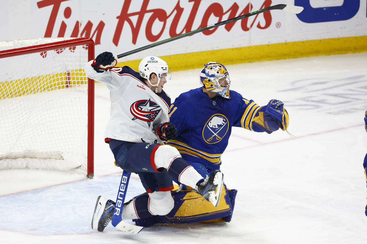 Columbus Blue Jackets left wing Eric Robinson and Buffalo Sabres goaltender Craig Anderson collide ...