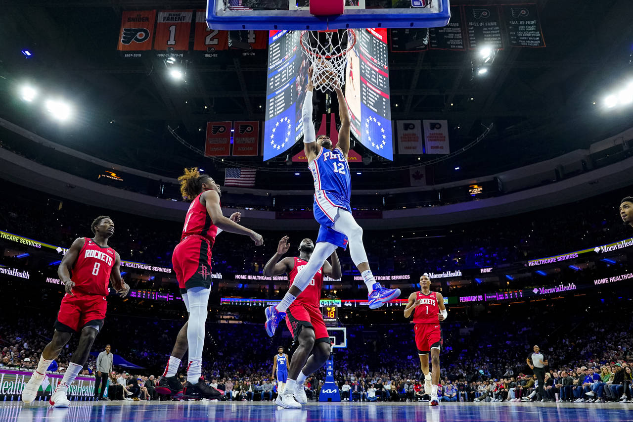 Philadelphia 76ers' Tobias Harris dunks the ball as the Houston Rockets look on during the first ha...