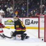 
              Detroit Red Wings' Pius Suter (24) scores against Vancouver Canucks goalie Collin Delia (60) during the third period of an NHL hockey game in Vancouver, British Columbia, Monday, Feb. 13, 2023. (Darryl Dyck/The Canadian Press via AP)
            