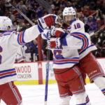 
              New York Rangers left wing Artemi Panarin (10) celebrates during the third period with left wing Jimmy Vesey (26) and center Vincent Trocheck (16) after his second goal of an NHL hockey game against the Carolina Hurricanes, Saturday, Feb. 11, 2023, in Raleigh, N.C. (AP Photo/Chris Seward)
            