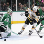 
              Dallas Stars goaltender Jake Oettinger (29) deflects a shot from Boston Bruins' Pavel Zacha (18) as Ryan Suter, right, helps defend on the play in the second period of an NHL hockey game, Tuesday, Feb. 14, 2023, in Dallas. (AP Photo/Tony Gutierrez)
            