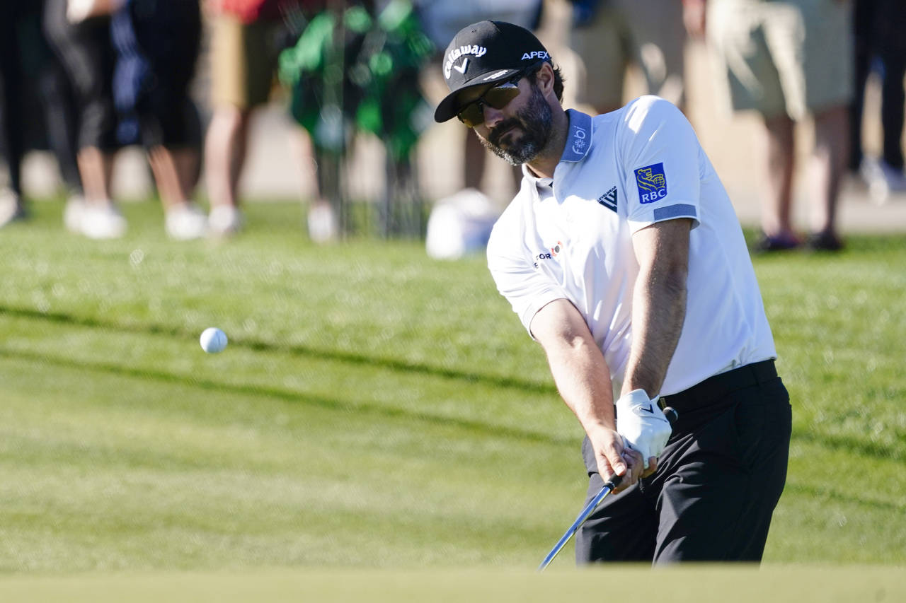 Adam Hadwin chips to the ninth green during the first round of the Phoenix Open golf tournament Thu...