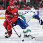 
              Detroit Red Wings center Dylan Larkin (71) chases the puck around Vancouver Canucks center Elias Pettersson (40) in the second period of an NHL hockey game Saturday, Feb. 11, 2023, in Detroit. (AP Photo/Paul Sancya)
            