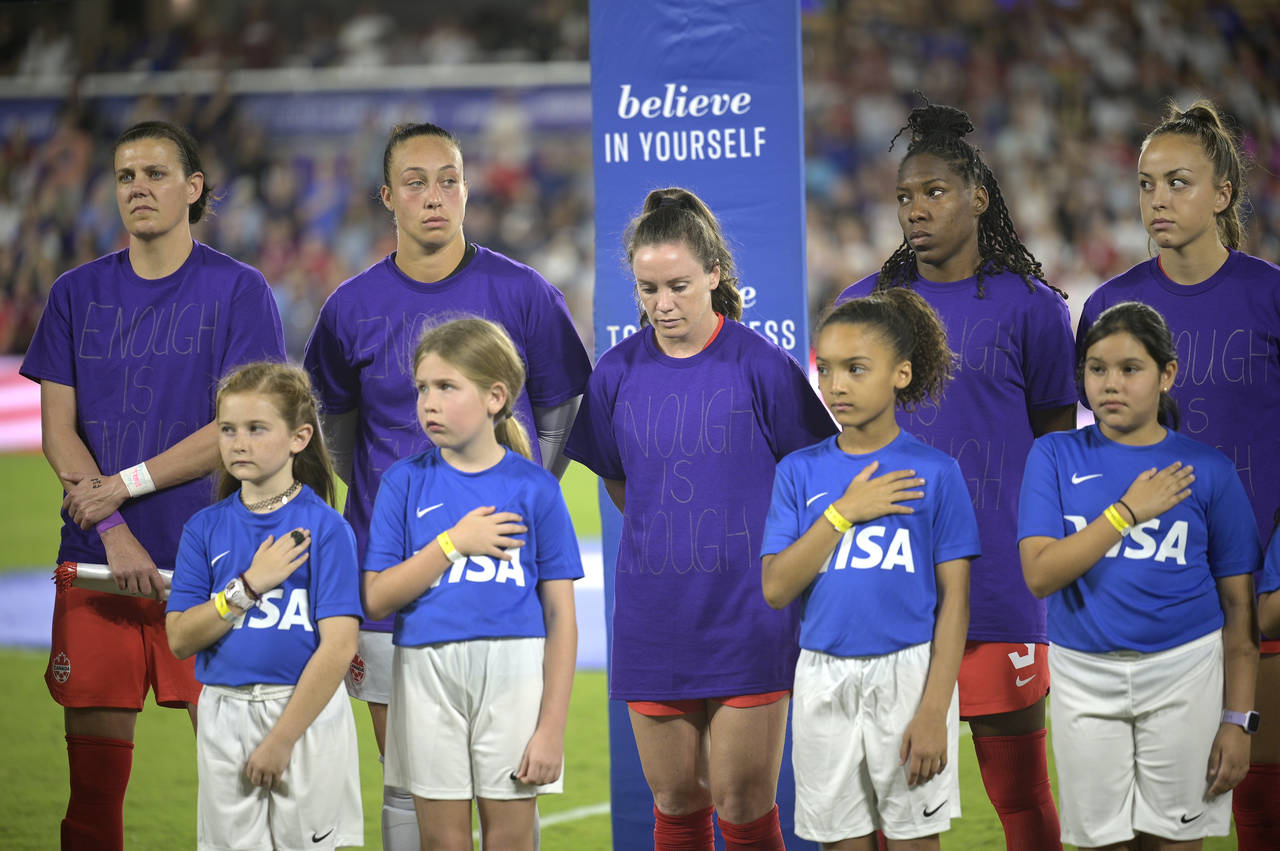 Canada players wear purple shirts with "Enough is Enough" written on them during the national anthe...