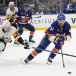 
              New York Islanders center Kyle Palmieri (21) reaches for the puck next to Pittsburgh Penguins defenseman Chad Ruhwedel (2) during the second period of an NHL hockey game Friday, Feb. 17, 2023, in Elmont, N.Y. (AP Photo/Mary Altaffer)
            