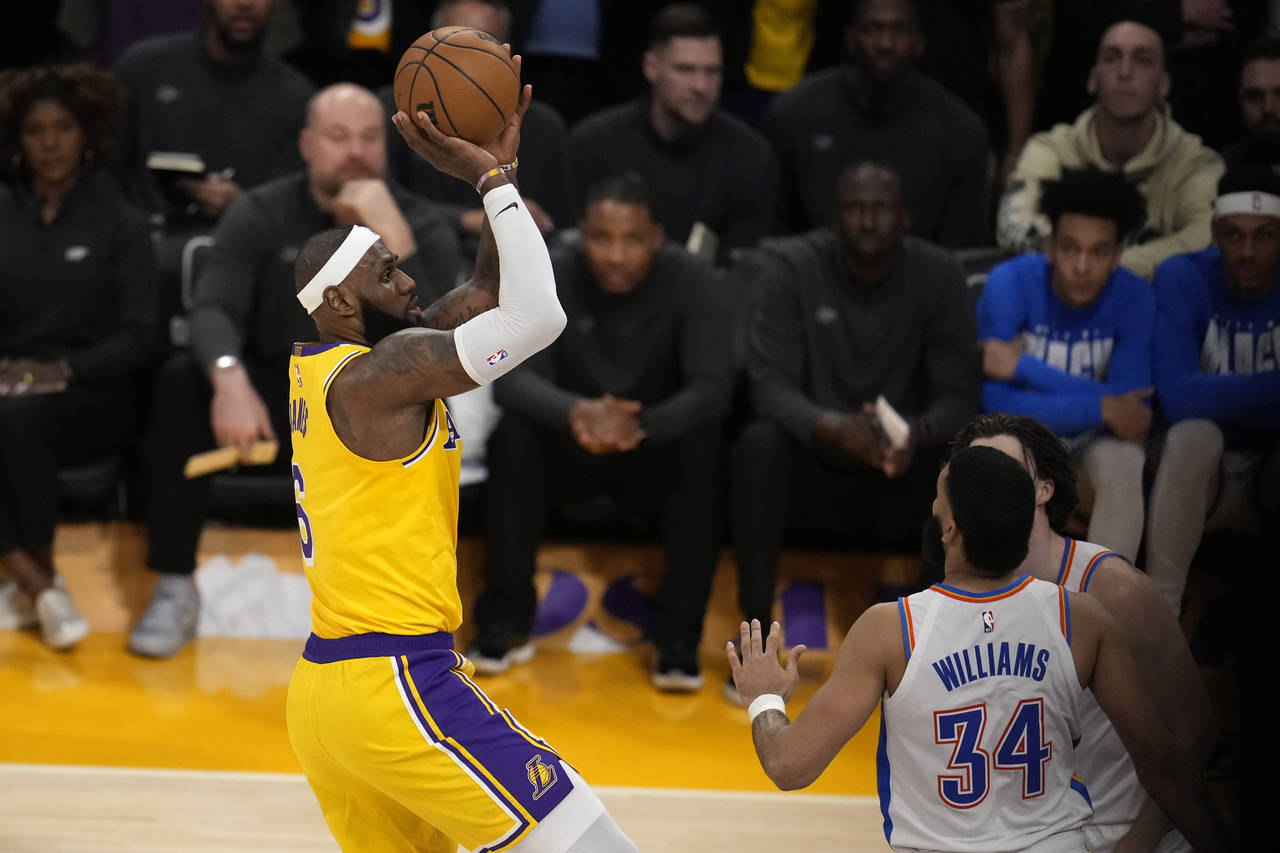 Los Angeles Lakers forward LeBron James, left, scores to pass Kareem Abdul-Jabbar to become the NBA...