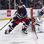 
              Winnipeg Jets' Adam Lowry (17) carries the puck as Los Angeles Kings goaltender Pheonix Copley (29) defends the net during the second period of an NHL hockey game in Winnipeg, Manitoba, on Tuesday, Feb. 28, 2023. (Fred Greenslade/The Canadian Press via AP)
            