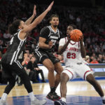 
              St. John's forward David Jones (23) drives to the basket as Providence guard Jared Bynum (4) and forward Bryce Hopkins (23) defend during the second half of an NCAA college basketball game, Saturday, Feb 11, 2023 in New York. (AP Photo/Bryan Woolston)
            
