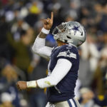 
              FILE - Dallas Cowboys quarterback Dak Prescott (4) points upward after scoring against Washington Commanders during the first half an NFL football game, Sunday, Jan. 8, 2023, in Landover, Md. While its Super Bowl commercial appearances are few, religion – Christianity especially – is entrenched in football culture. (AP Photo/Patrick Semansky, File)
            