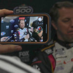 
              A reporter makes a video interview on his cell phone with Brad Keselowski during NASCAR Daytona 500 auto race media day at Daytona International Speedway, Wednesday, Feb. 15, 2023, in Daytona Beach, Fla. (AP Photo/John Raoux)
            