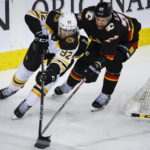 
              Boston Bruins forward Tomas Nosek, left, is checked by Calgary Flames forward Trevor Lewis during the second period of an NHL hockey game Tuesday, Feb. 28, 2023, in Calgary, Alberta. (Jeff McIntosh/The Canadian Press via AP)
            