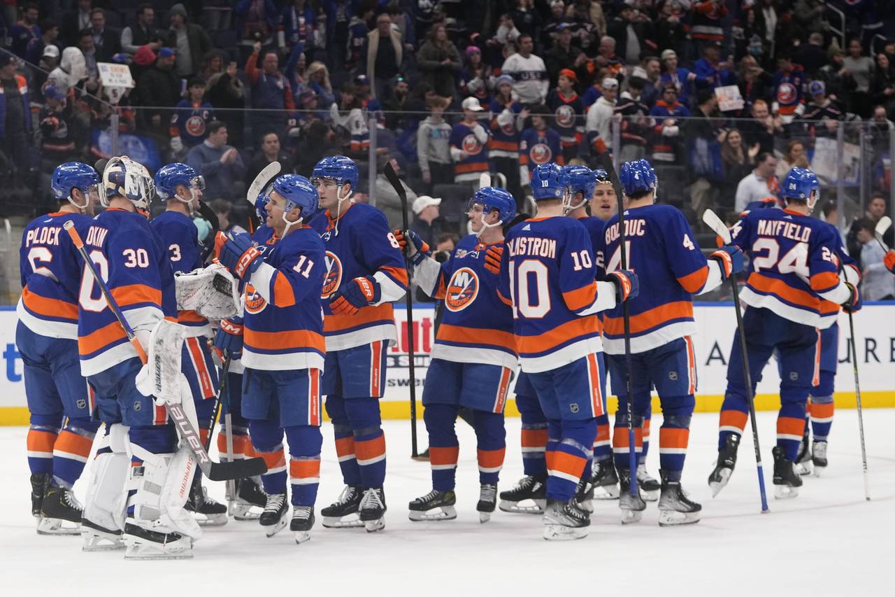 New York Islanders' Zach Parise (11) and goaltender Ilya Sorokin (30) celebrate with teammates afte...