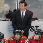 
              Chicago Blackhawks head coach Luke Richardson, top, stands behind the bench during the second period of an NHL hockey game against the Arizona Coyotes, Friday, Feb. 10, 2023, in Chicago. (AP Photo/David Banks)
            