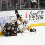 
              Anaheim Ducks' Derek Grant (38) and Pittsburgh Penguins' Brian Dumoulin (8) crash into the boards while chasing the puck during the third period of an NHL hockey game Friday, Feb. 10, 2023, in Anaheim, Calif. The Penguins won 6-3. (AP Photo/Jae C. Hong)
            