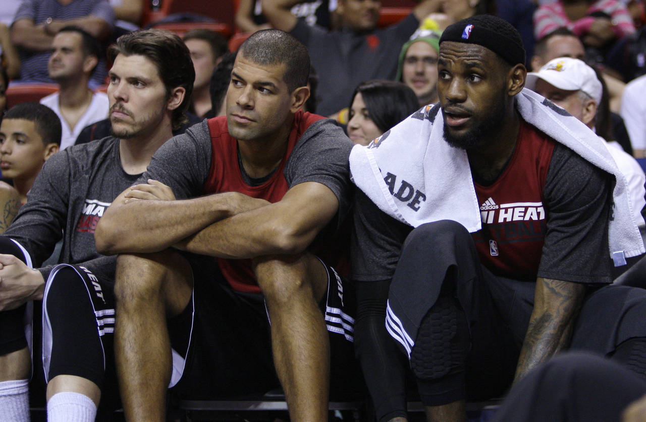 FILE - Miami Heat's Mike Miller, left, Shane Battier, center, and LeBron James, right, watch from t...