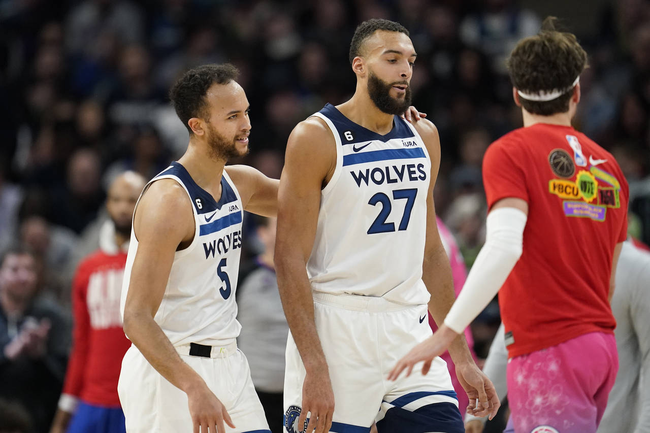 Minnesota Timberwolves forward Kyle Anderson (5), left, and center Rudy Gobert (27) react after a t...