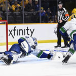 
              Vancouver Canucks goaltender Collin Delia (60) dives to block a shot by Nashville Predators left wing Tanner Jeannot (84) during the second period of an NHL hockey game Tuesday, Feb. 21, 2023, in Nashville, Tenn. (AP Photo/Mark Zaleski)
            