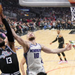 
              Los Angeles Clippers forward Paul George, left, grabs a rebound away from Sacramento Kings forward Domantas Sabonis during the first half of an NBA basketball game Friday, Feb. 24, 2023, in Los Angeles. (AP Photo/Mark J. Terrill)
            